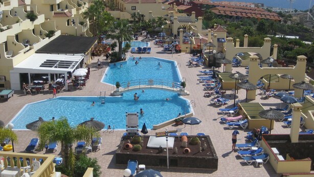 Resort com várias piscinas, espreguiçadeiras e guarda-sóis.