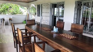 A long wooden dining table with six chairs, a small table lamp, and decorative mats. - Deux-Palmes-Kribi, close to the beach (200m), comfortable and family-friendly (Kribi)
