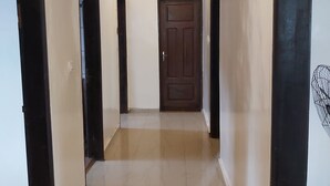 A hallway with a wooden ceiling, a tiled floor, and a door at the end. - Deux-Palmes-Kribi, close to the beach (200m), comfortable and family-friendly (Kribi)