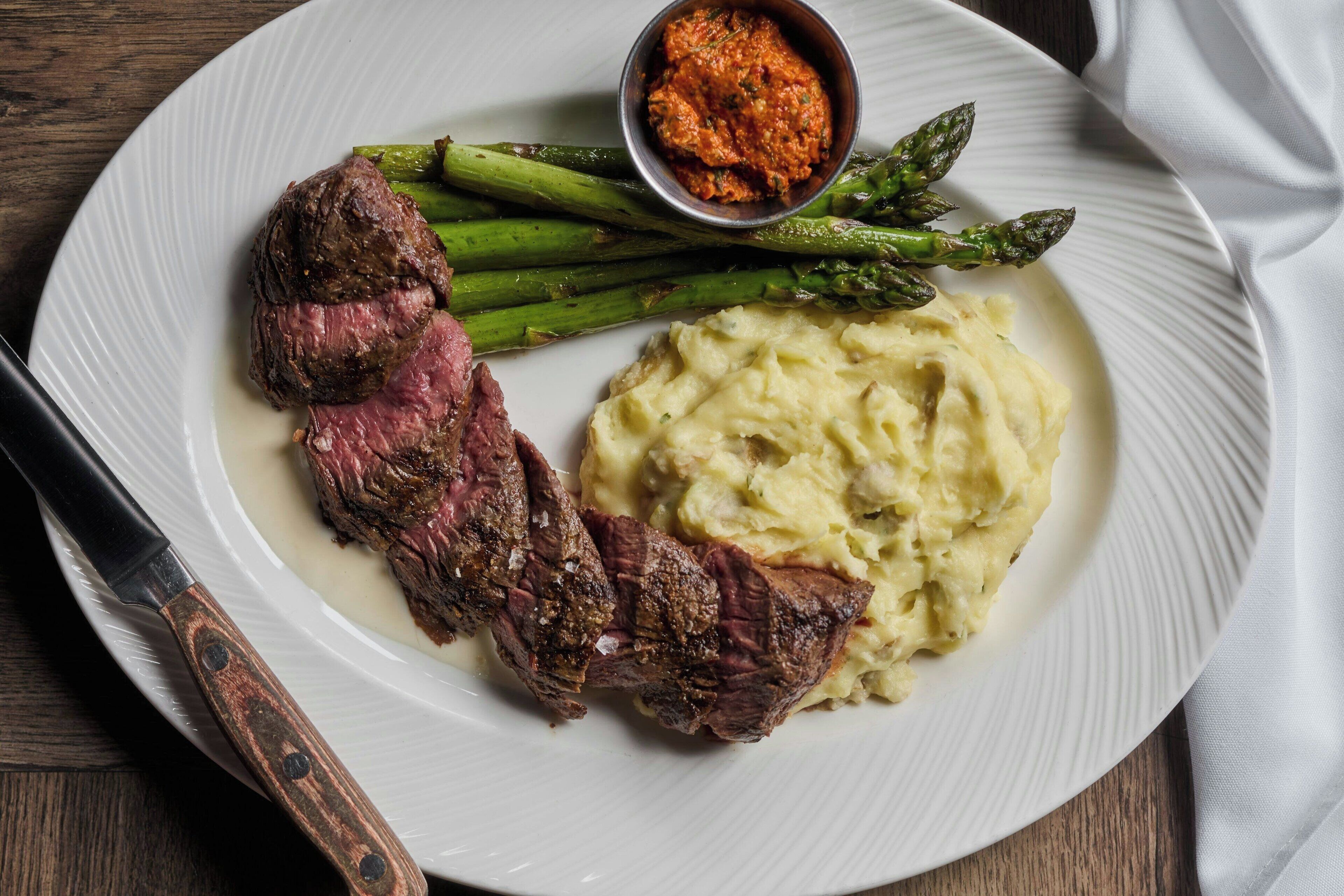 A plate with steak, asparagus, and mashed potatoes.