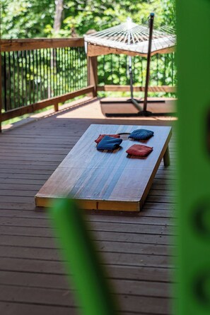 A wooden deck with a bench and two cushions. - Sunrays - Hot Tub, Outdoor Fireplace & Game (Morganton)