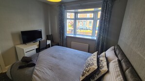 A hotel room with a bed, a TV, a desk, and a window with a view of the outside. - Ravenhill Town house  Belfast (Belfast)