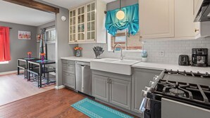 A modern kitchen with a dishwasher, sink, stove, and cabinets.