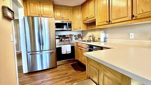 A kitchen with wooden cabinets, stainless steel appliances, a microwave, and a sink. - Iconic Dahlonega View! In Town! WINE GOLD HIKING (Dahlonega)