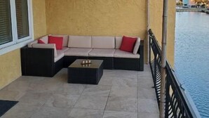 A balcony with a sofa, a coffee table, and a ceiling fan. - Pensacola Beach - 4 Bedrooms w/ Beach and Pool Access! (Pensacola Beach)