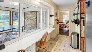 A kitchen with a large window, a dining table, and chairs. There is a refrigerator, a sink, and a trash can. - Timber View Retreat-Large 4 BR close to shopping & restaurants in NE Longview (Longview)