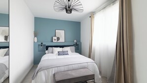 A modern bedroom with a bed, bench, and artwork on the wall.