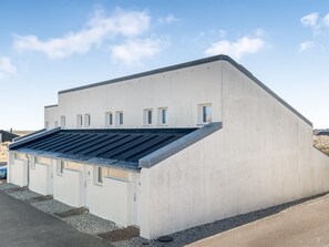 A modern building with a flat roof, multiple windows, and a concrete facade.