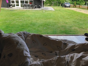 Makuuhuoneesta avautuu näkymä takapihalle, jossa on patio, ulkokalusteita ja auto, joka on pysäköity ulos.