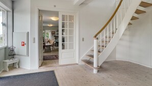Un intérieur moderne avec un escalier, une porte donnant sur une autre pièce et une fenêtre.