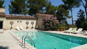 A swimming pool with clear blue water, surrounded by lounge chairs and potted plants. - La Rouvraie - FLAYOSC (FLAYOSC)