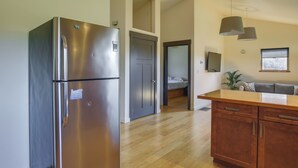Eine moderne Küche mit einem Edelstahl-Kühlschrank, Holzschränken und einer Holz Arbeitsplatte.