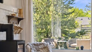 Una habitación acogedora con chimenea, un sillón cómodo y vistas al exterior.