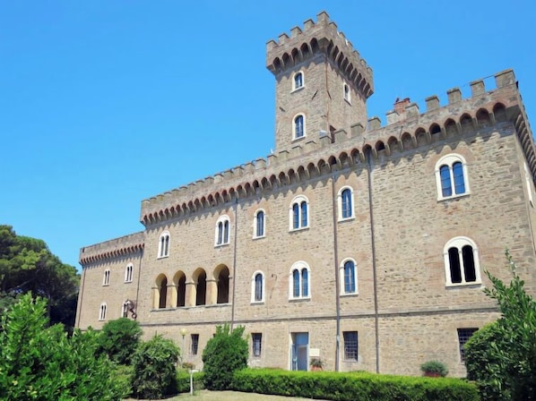 A large stone building with a central tower, multiple arched windows, and a symmetrical facade.