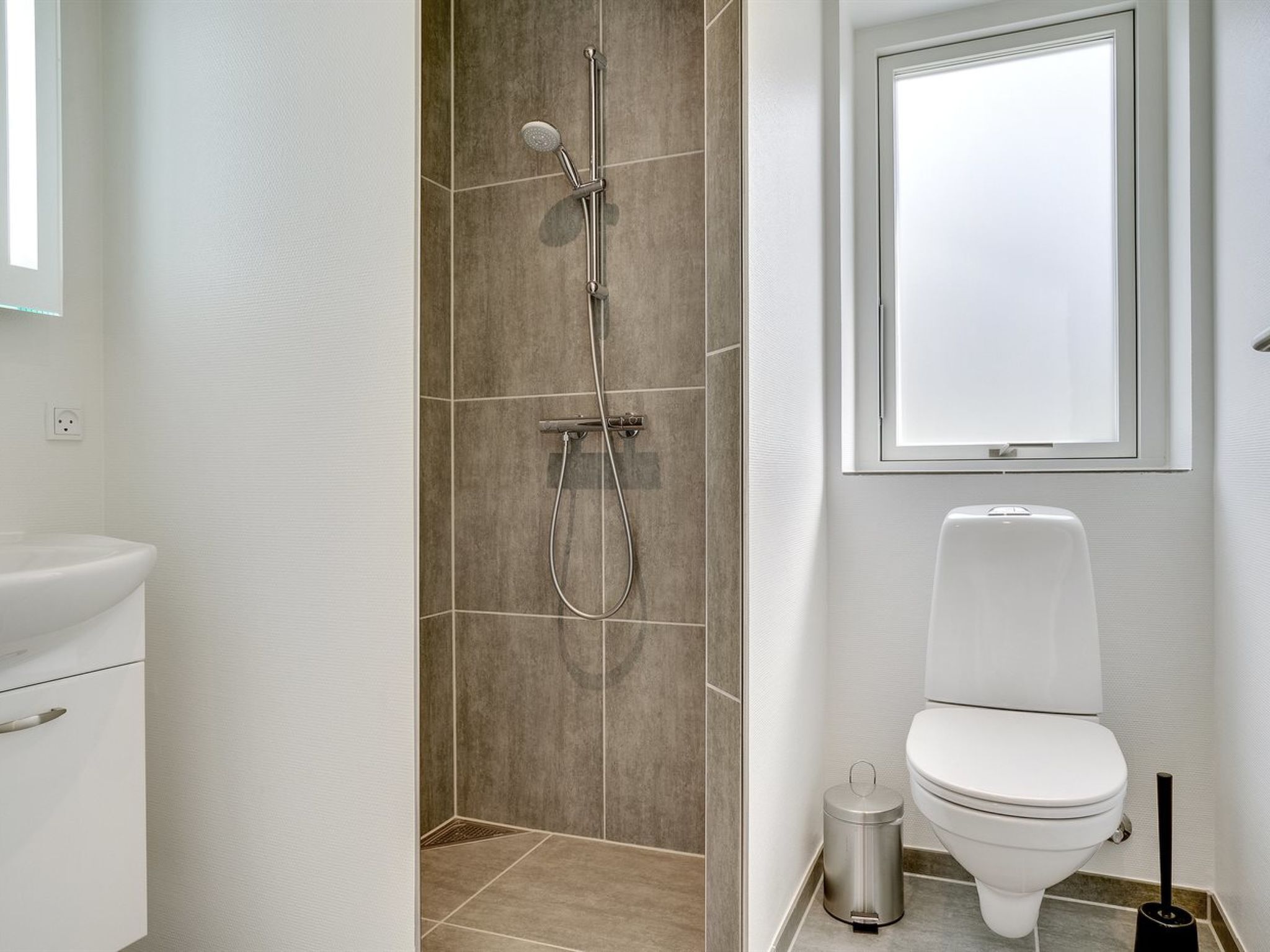 A bathroom with a shower, toilet, and sink.