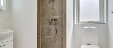 A bathroom with a shower, toilet, and sink.
