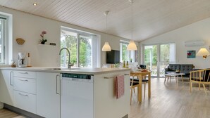 A modern kitchen with a dishwasher, a dining area with a table and chairs, and a living room with a sofa and a TV. - "Alona" - 250m from the sea by Interhome (Jerup)