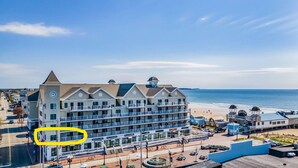 A multi-story hotel with balconies and a beach view.