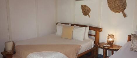 A bed with a wooden frame, a bedside lamp, and a wall-mounted air conditioner.