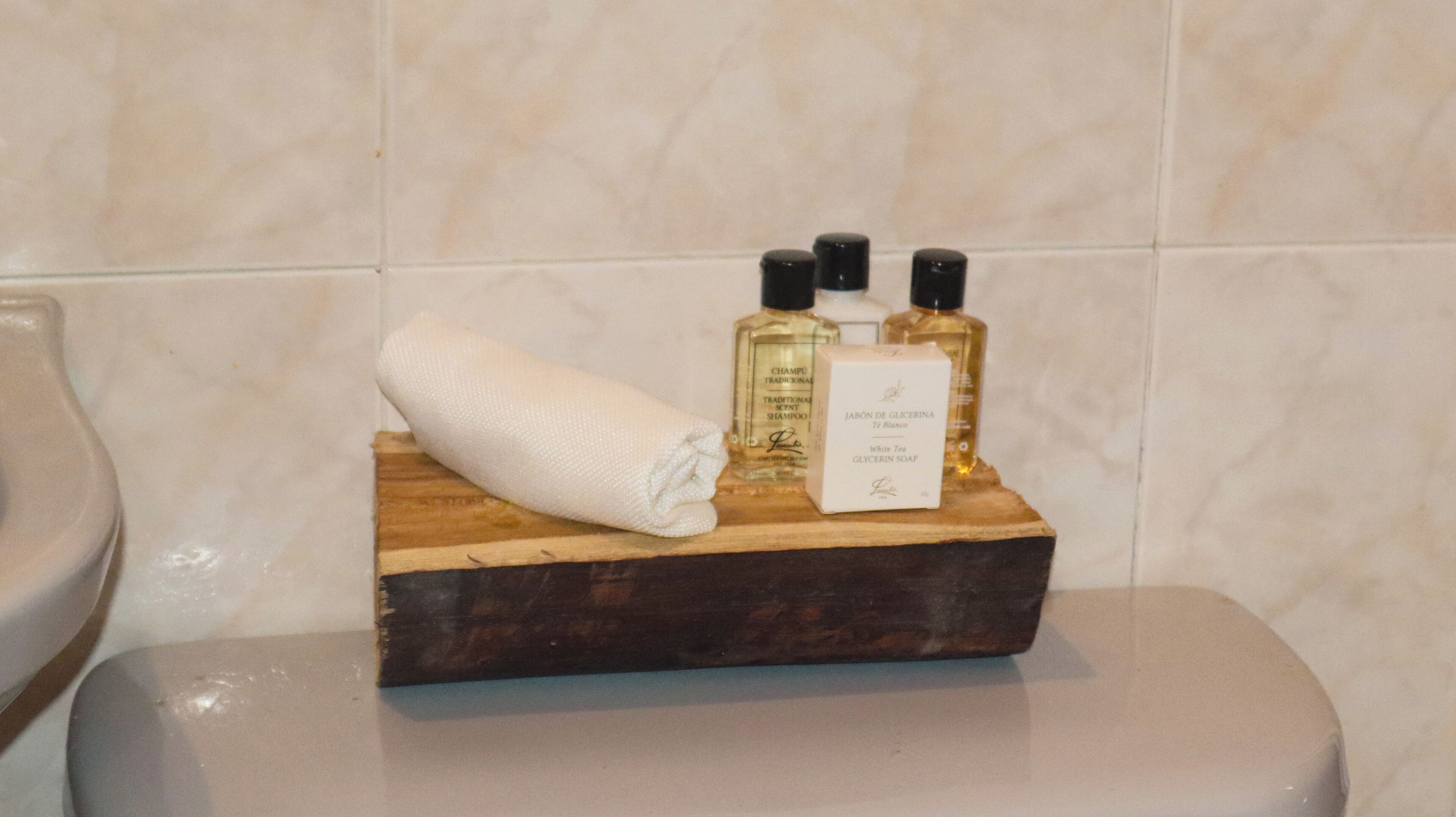 Een houten dienblad met toiletartikelen op een badkamermeubel.