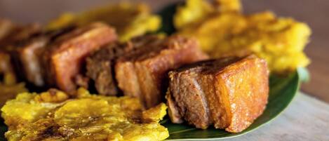 A plate of fried plantains and pork belly.