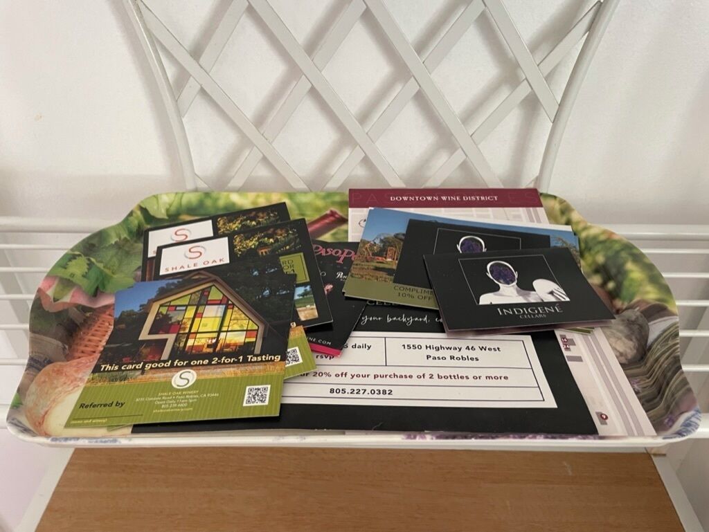 A box containing wine tasting cards and a business card with a PO address.