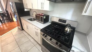 A modern kitchen with white cabinets, a stainless steel stove, and a microwave. - Charming 2-bedroom apartment in lovely Brooklyn, 20mins to Manhattan (Brooklyn)