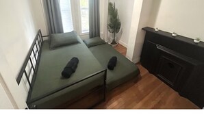 A compact room with two single beds, a small desk, and a potted plant. - Charming 2-bedroom apartment in lovely Brooklyn, 20mins to Manhattan (Brooklyn)