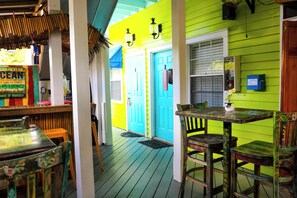 A brightly colored interior with a wooden table and chairs, a blue door, and a green wall.