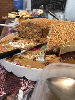 Un pastel grande con cobertura desmenuzable y relleno cremoso, cortado parcialmente.