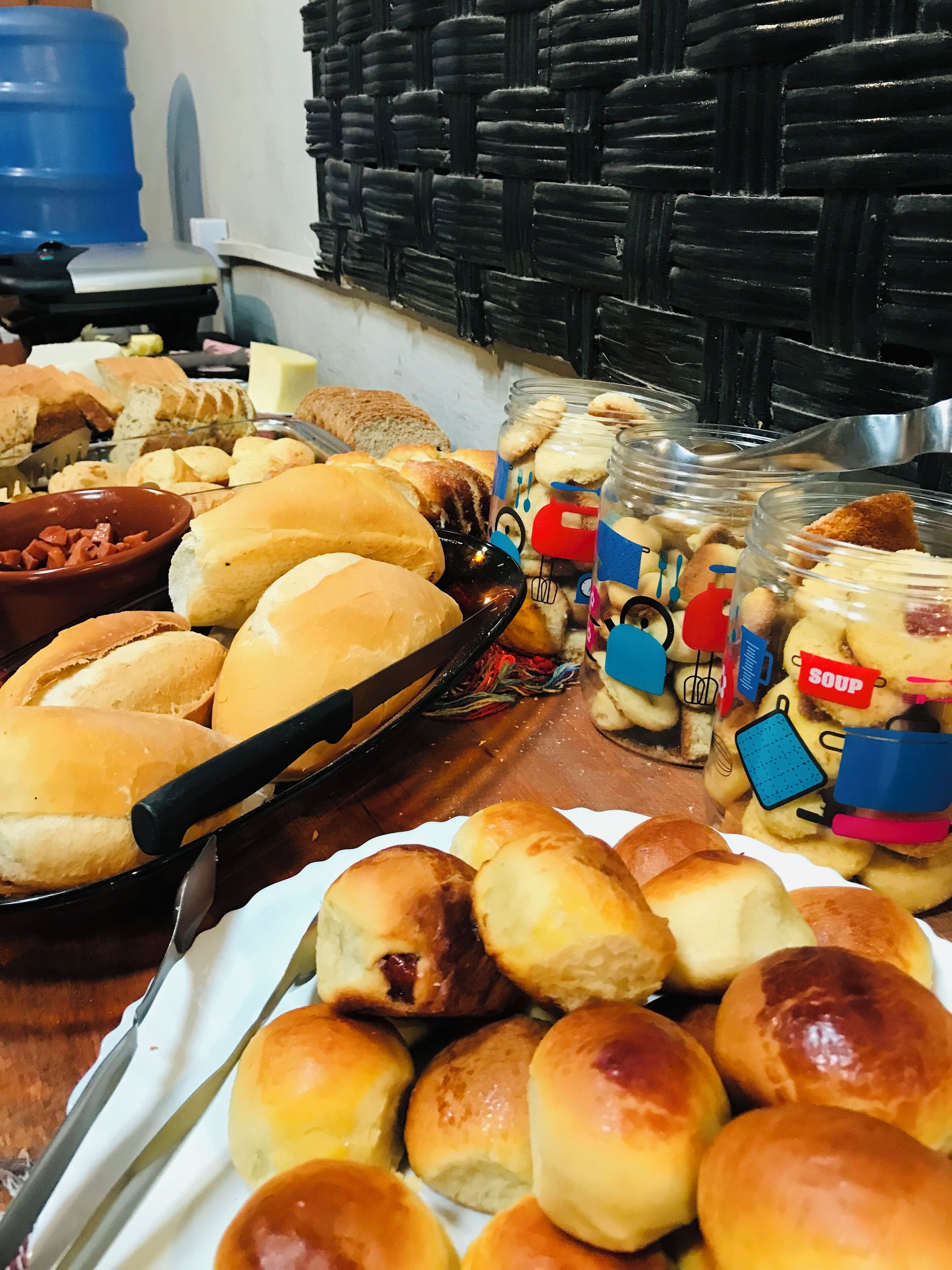 Ein reichhaltiges Buffet mit verschiedenen Speisen, darunter Brötchen, Brot und Gläser mit Besteck.