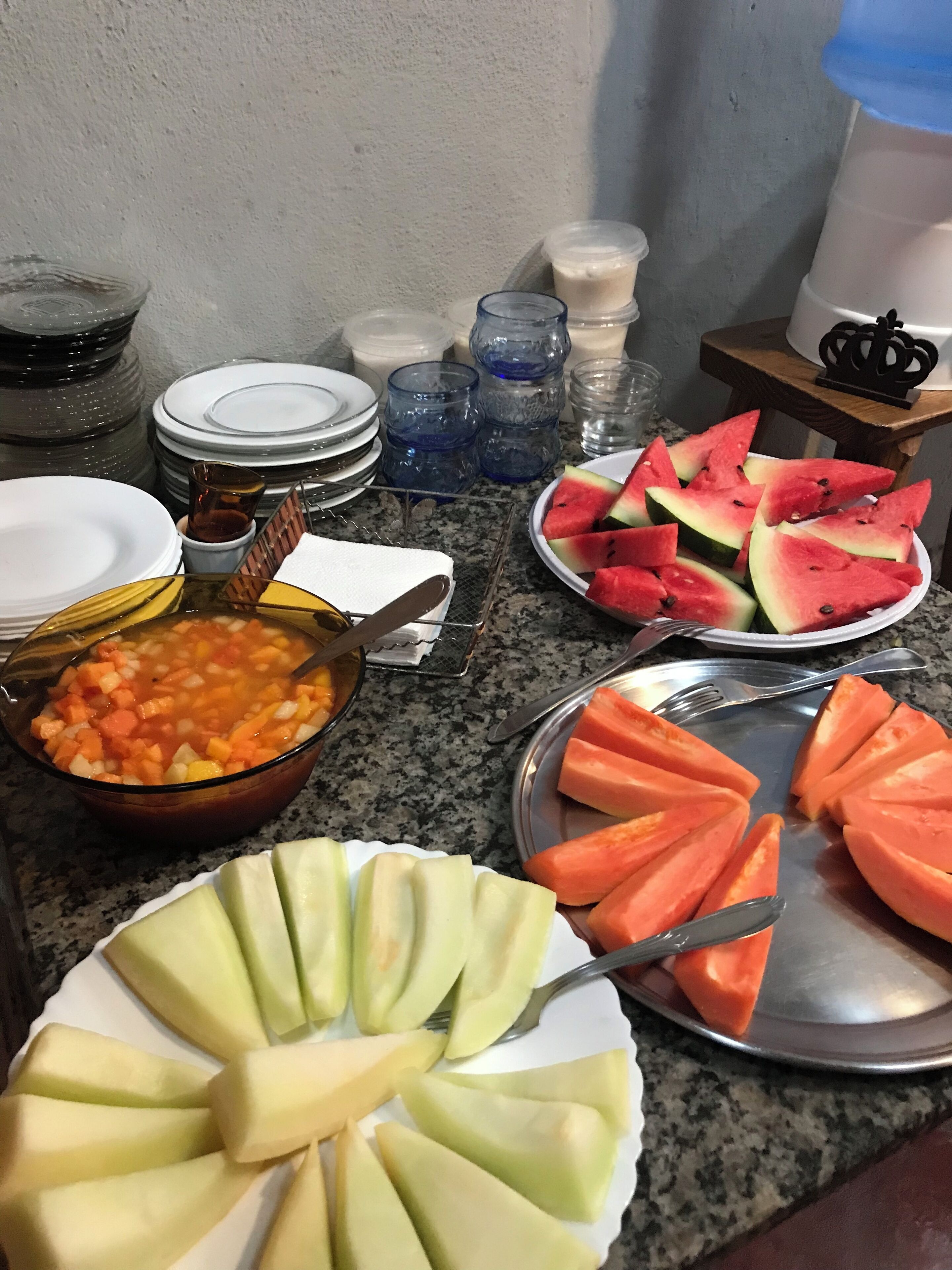 Ett bord med ett urval av olika frukter och en skål med soppa.