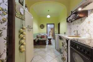 A kitchen with a dining area, featuring a refrigerator, stove, and tiled backsplash. - San Niccolò Elegant Apartment (Firenze)