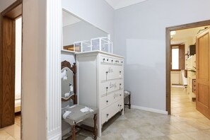 A hallway with a white dresser, a bench, and a mirror. - San Niccolò Elegant Apartment (Firenze)