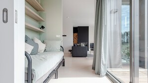 Et moderne soveværelse med seng, skrivebord og balkon med udsigt.