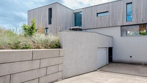 En moderne bygning med en betonfacade og store vinduer.