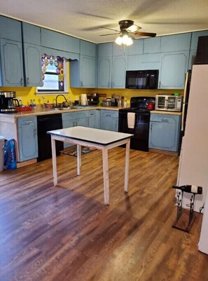 Kitchen features a microwave, ceiling fan, and wine rack.
