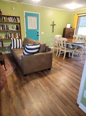 Relax in this inviting space with a leather sofa, bookshelf, and dining table.