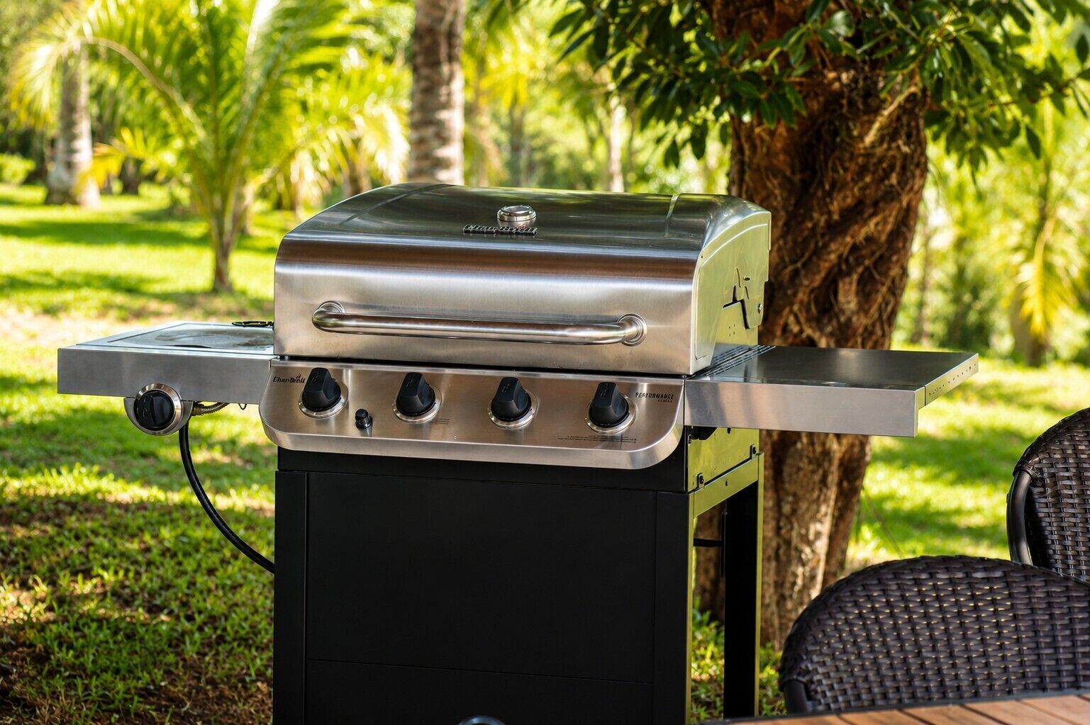 Un barbecue d’extérieur en acier inoxydable, doté de quatre brûleurs, d’un écran numérique et d’une étagère latérale.