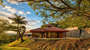 Une maison avec un toit recouvert de tuiles rouges, un mur en pierre et une vue sur le paysage environnant.