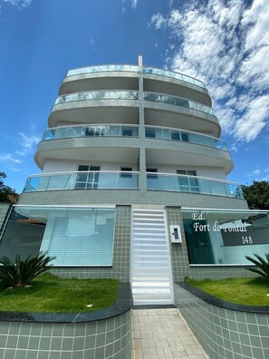 Un edificio moderno de varios pisos, con balcones y ventanas grandes.