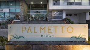 A sign for 'Palmetto Beach' with a modern building in the background. - Cartagena Home with a Heavenly View (Cartagena)
