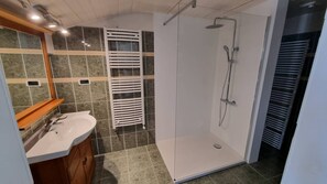 Enjoy a refreshing shower in this bathroom with a walk-in shower, sink, and mirror.