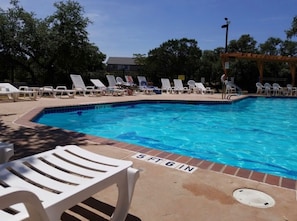 Relax by the pool surrounded by lush greenery and comfortable lounge chairs.