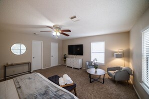 Cozy living space with a flat-screen TV, round window, and comfortable seating area.