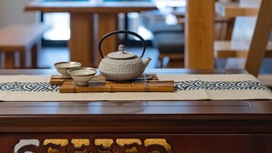 A traditional Japanese tea set on a tatami mat with a wooden table and a window in the background. - Certify Kyomachiya [Himoewya] Fully furnished house with a walk to Kiyomizu-dera Temple, Chiji-in Temple, Yasaka Shrine and Kyoto National Museum of Art. (京都市)