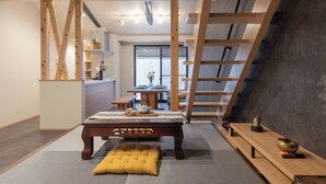 A modern interior with a dining table, a bench, a ladder, and a tatami mat floor. - Certify Kyomachiya [Himoewya] Fully furnished house with a walk to Kiyomizu-dera Temple, Chiji-in Temple, Yasaka Shrine and Kyoto National Museum of Art. (京都市)