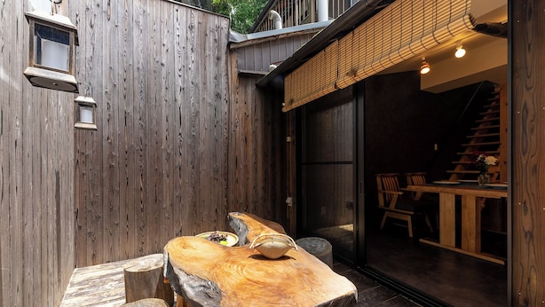 A rustic wooden table with a bowl and a plate, a wooden bench, and a wooden fence. - Certify Kyomachiya [Himoewya] Fully furnished house with a walk to Kiyomizu-dera Temple, Chiji-in Temple, Yasaka Shrine and Kyoto National Museum of Art. (京都市)
