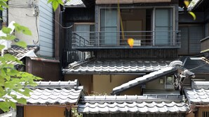 A traditional Japanese building with a wooden door, a balcony, and a tiled roof. - Certify Kyomachiya [Himoewya] Fully furnished house with a walk to Kiyomizu-dera Temple, Chiji-in Temple, Yasaka Shrine and Kyoto National Museum of Art. (京都市)