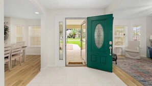 A spacious room with a green door, white walls, and a tiled floor. - Spacious Beachy Retreat with Heated Pool! Short walk to beach•Pet friendly•Bikes (St. Augustine)